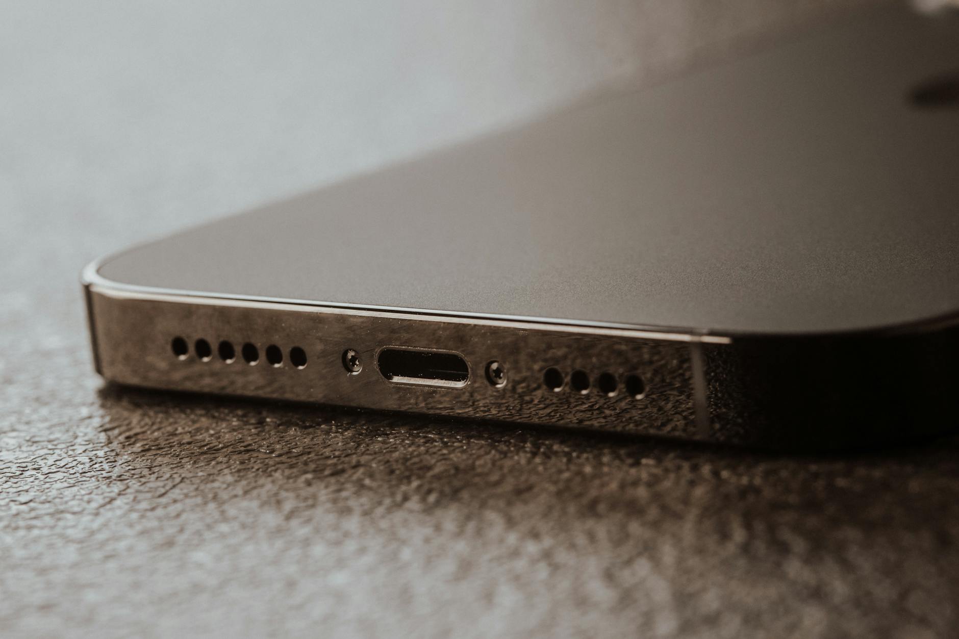 Jak samodzielnie zdiagnozować i naprawić uszkodzone gniazdo ładowania w telefonie krok po kroku Zbliżenie uszkodzonego gniazda ładowania w smartfonie na stole
