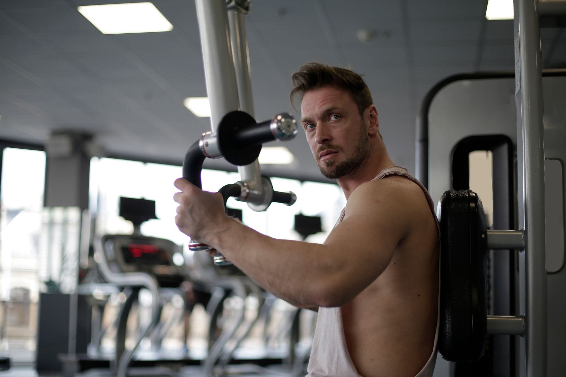 Skupiony mężczyzna trenuje biceps na siłowni